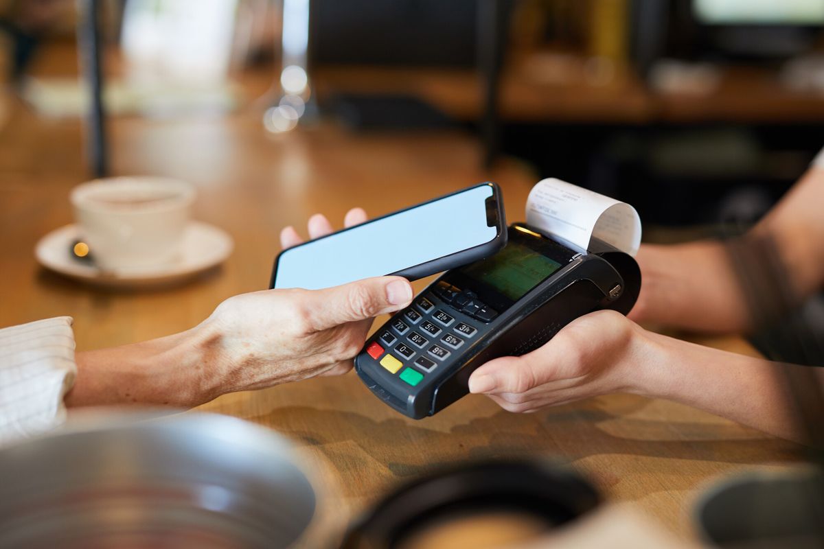 A customer paying by phone at a card terminal